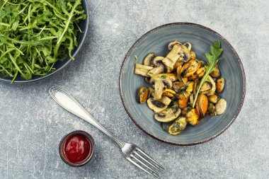 Kızarmış midye ve kızarmış şampiyon mantarlı deniz ürünleri..