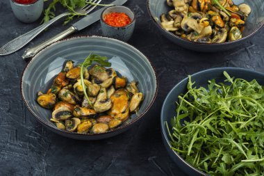 Hafif sarımsak soslu midyeli ve mantarlı sıcak salata. Ev yapımı deniz ürünleri yemeği..