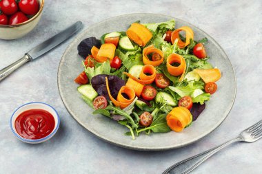 Taze bahar salatası, karışık sebzeler ve sebzeler tabakta servis edilir. Hafif vejetaryen yemeği ve mevsimsel sağlıklı yiyecekler.