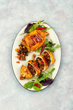 Porsiyonlara dilimlenmiş ızgara doldurulmuş kalamar ve sebze dolgusu ve taze salata yapraklarıyla servis ediliyor. Gurme deniz ürünleri yemeği..