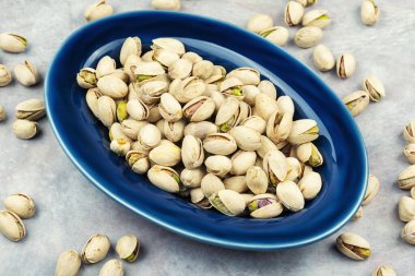 Seramik tabakta servis edilen kavrulmuş kabuklu fıstık..