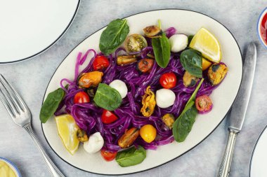 Hafif ve besleyici sebze makarnası patates eriştesi, üstüne midye ve taze mozzarella. Üst görünüm.