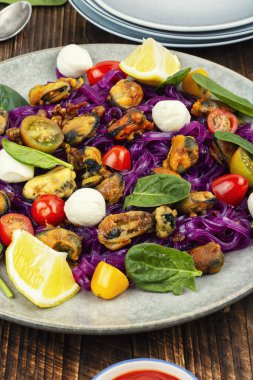 Modern tabakta midye, ıspanak, mozarella ve renkli sebzeli sağlıklı patates bazlı makarna..