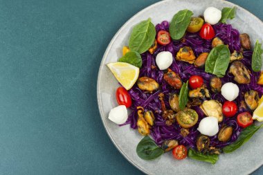 Patates kurdelesinden yapılmış sebze fettuccine makarna, kızarmış midye, vişneli domates ve yumuşak mozarella ile servis edilir. Boşluğu kopyala.