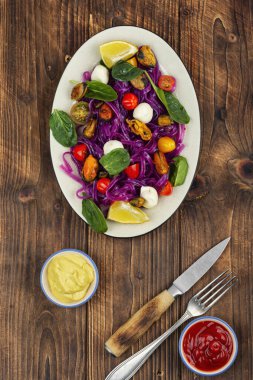 Tahta masada midyeli, ıspanaklı, kirazlı domatesli ve peynirli patates fettuccine tabağı..