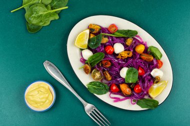 Patatesten yapılmış sebze fettuccine makarna, kızarmış midye, domates ve yumuşak mozzarella ile servis edilir. Glütensiz makarna. Üst görünüm.