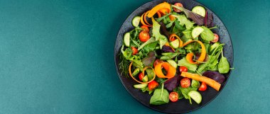 Taze yapraklı sebze salatası, salatalık, vişneli domates ve havuç kurdelesi. Metnin için boş alan, uzun pankart.