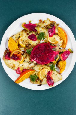 Balık tabağı. Tropikal pitahaya ile kızarmış balık filetosu ve portakallar. Ev yapımı sağlıklı yemekler..