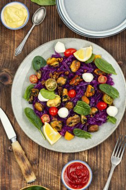 Sağlıklı deniz ürünleri makarnası, midyeli patates esaslı makarna, ıspanak, ahşap desenli bir yüzeyde mozzarella..