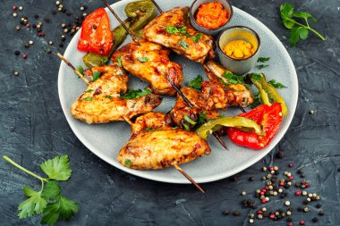 Ahşap çubuklarda ızgara tavuk kanadı..