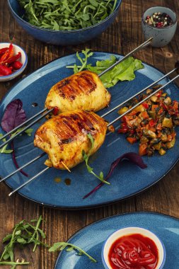 Doldurulmuş kalamar dolması mükemmelce kızartılmış ve zengin sebze dolgulu şişler ile servis edilmiş. Deniz ürünleri konsepti,