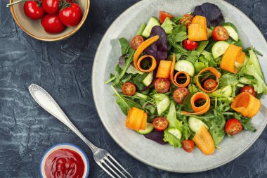 Taze bahar yeşillikleri, taze sebzeler ve bir tabakta sıralanmış şifalı otlar. Genel Görünüm.