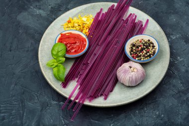 Doğal baharat ve otlarla pişirmek için hazırlanmış tatlı patatesten yapılmış mor sebze makarnası. Temiz yemek konsepti ve yaratıcı vegan mutfak hazırlığı..