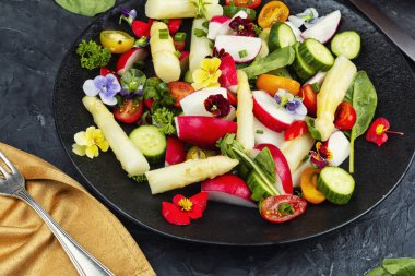 Mevsimlik malzemeler ve beyaz kuşkonmazla hazırlanmış taze sebze salatası. Tabakta servis edilen sağlıklı bitki temelli yemek. Yemek fotoğrafçılığı