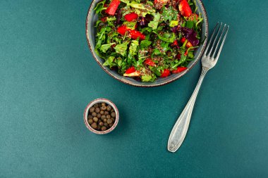 Dilimlenmiş kırmızı dolma biber, vişneli domates, keten ve susam tohumlu taze karışık salatanın zarif kompozisyonu. Boşluğu kopyala.