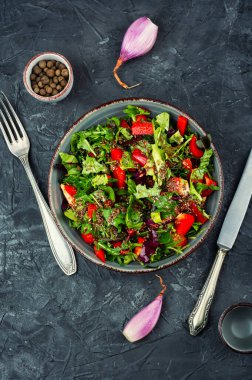 Kırmızı dolma biberli taze yeşil salata, kiraz domatesleri, keten tohumu ve seramik kasede servis edilen susam tohumları. Sağlıklı yemek. Üst görünüm.