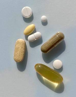 Tıbbi bakım hapları, haplar ve multi vitaminler gri arka planda yatıyordu. Sağlık ve Sağlık.