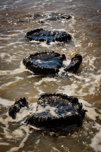 Posti frangiflutti in decomposizione che conducono in mare — Foto Stock