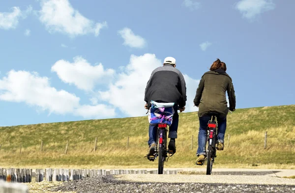 A couple cycling on a causeway in Zeeland — Stock Photo, Image