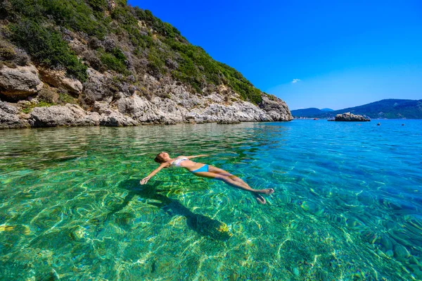 アフィオナスのポルト ティモニ ビーチでリラックスして泳ぐ太陽の帽子を持つ女の子は コルフ島 イオニア島 ギリシャ ヨーロッパで透明な紺碧の水を持つ楽園のダブルビーチです — ストック写真
