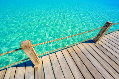 Ahşap güverte ve mavi suyun arka planı - Cennet 'te tropikal bir manzara