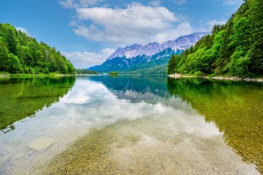 Arka planda Zugspitze Dağı olan Eibsee Gölü. Cennet plajlı güzel manzara ve Alman Alplerinde berrak mavi su - Garmisch Partenkirchen, Grainau - Bavyera, Almanya, Avrupa.