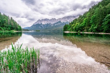 Arka planda Zugspitze Dağı olan Eibsee Gölü. Cennet plajlı güzel manzara ve Alman Alplerinde berrak mavi su - Garmisch Partenkirchen, Grainau - Bavyera, Almanya, Avrupa.