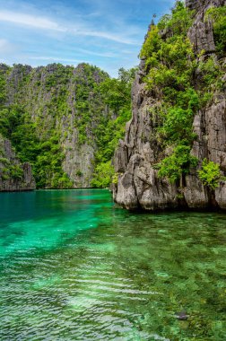 Coron adasındaki Kayangan Gölü 'ndeki ahşap rıhtımda teknelerle Cennet Koyu' nda mavi kristal su, tropikal seyahat yeri - Palawan, Filipinler.