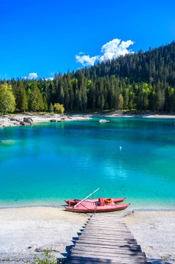 Boat on the shore of Cauma Lake (Caumasee) with crystal blue water in beautiful mountain landscape scenery at Flims, Graubuenden - Switzerland