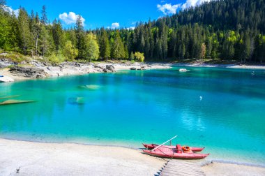 Boat on the shore of Cauma Lake (Caumasee) with crystal blue water in beautiful mountain landscape scenery at Flims, Graubuenden - Switzerland
