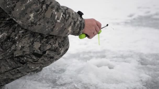 Winter Angelt Ein Fischer Aus Einem Eisloch — Stockvideo