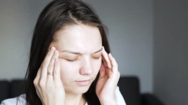 Kız el ve kaşlarıyla şakağını ovuyor, baş ağrısı 4K