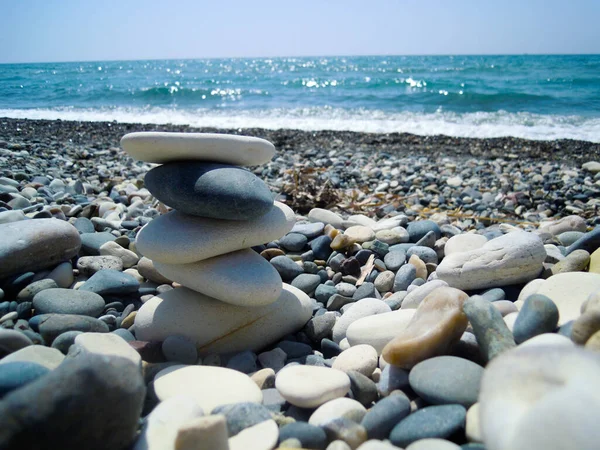 Deniz kenarında Cairn, güzel taşlar, mavi deniz, berrak gökyüzü.