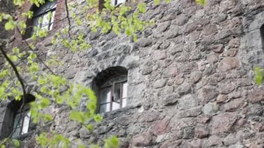 Ortaçağ kalesi, taş duvarlı pencereler, sokaktan manzara, gün.