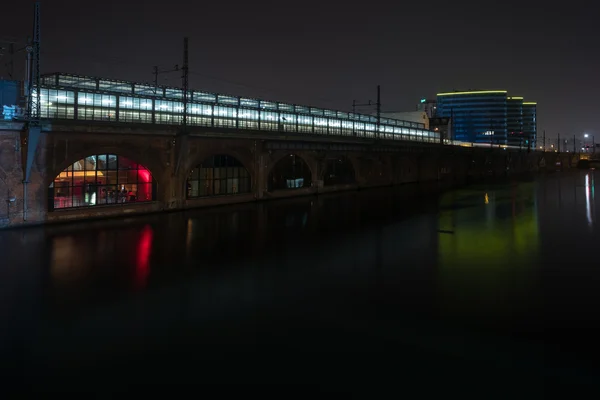 Tren urbano de plataforma ferroviaria (S-Bahn) y traslado a la estación de metro (U-Bahn) Jannowitz Bridge y al río Spree. Berlín de noche . —  Fotos de Stock