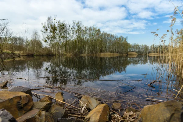 Frühling am See. Reflexion der Wolken im Wasser. — Stockfoto