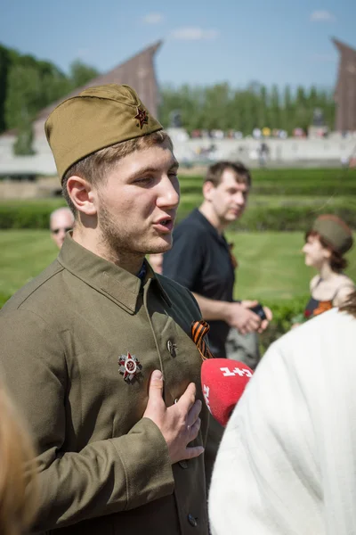 Jornalista ucraniano estação de TV 1 + 1 está entrevistando um jovem vestido na forma de um soldado soviético durante a guerra . — Fotografia de Stock