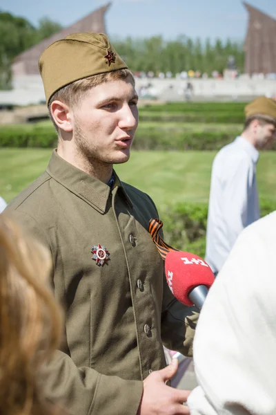 Periodista estación de televisión ucraniana 1 + 1 está entrevistando a un joven vestido en la forma de un soldado soviético durante la guerra . — Foto de Stock