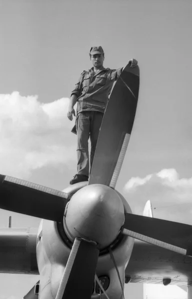 Un soldat stă pe aripă, lângă turbopropulsorul avionului militar de transport AN-24. Scanare de film. Cereale mari — Fotografie, imagine de stoc