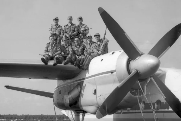 Un grup de soldați în picioare pe aripa unui avion de transport militar AN-24. Scanare de film. Cereale mari — Fotografie, imagine de stoc
