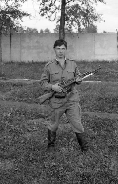 A soldier posing with guns. Film scan. Large grain — Stock Photo, Image