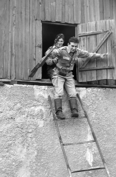 Two soldiers with weapons in the attic of an old house. Film scan. Large grain — Stock Photo, Image