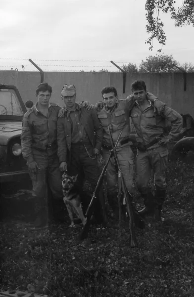 Eine Gruppe von Soldaten mit Waffen in der Nähe des Armee-Geländewagens uaz-469. Filmscan. Großkorn — Stockfoto