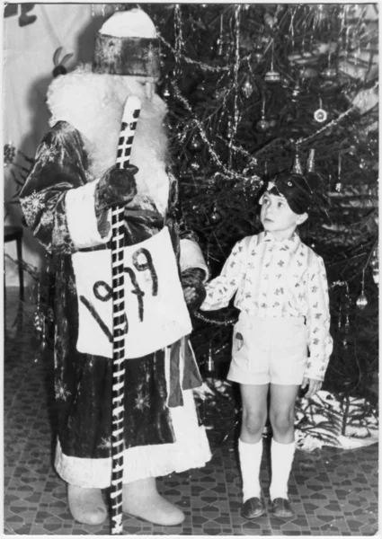 Traditional children's party, New Year party in the kindergarten. Celebrated on the eve of the new year. Father Frost with a boy — Stock Photo, Image