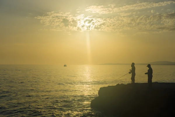 Evening fishing on the Mediterranean Sea. Turkey. Silhouette of fishermen. — Stock Photo, Image