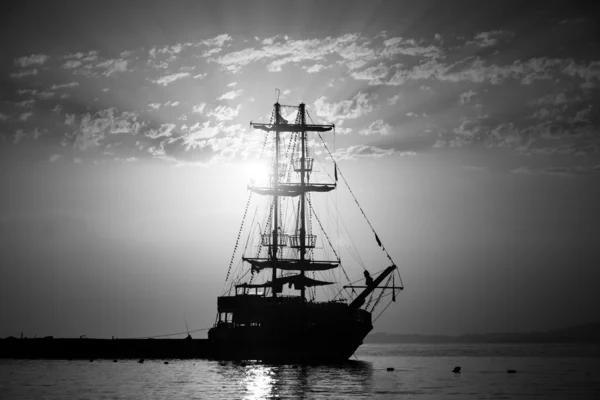 Evening. Sailboat in the bay. Black and white