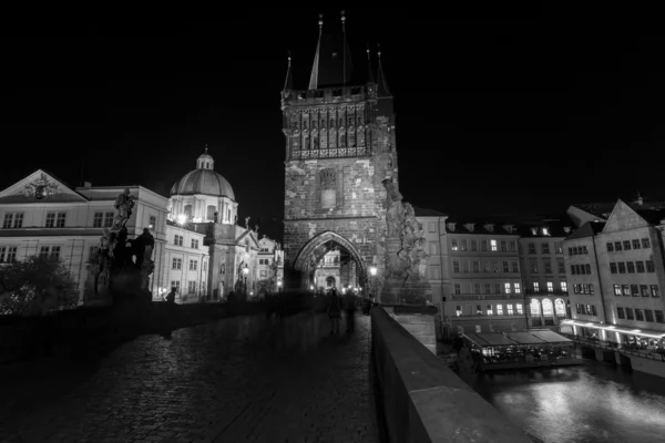 Tower Bridge on the Charles Bridge in the evening illumination. The Charles Bridge is a famous historic bridge that crosses the Vltava river. Black and white — Stock Photo, Image