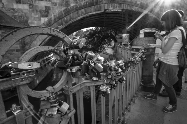 Padlocks on a metal fence channel. A symbol of fidelity. Black and white. Prague is the capital and largest city of the Czech Republic. — Stock Photo, Image