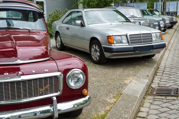 Retro carros de pé em uma fileira. Em primeiro plano um Volvo PV544, no fundo, em tamanho real carro de luxo Mercedes-Benz W124 Coupe — Fotografia de Stock