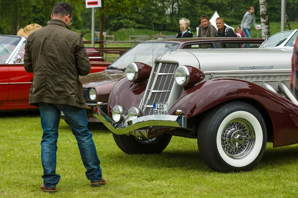 Um homem olha para o carro vintage Auburn 852 Speedster — Fotografia de Stock